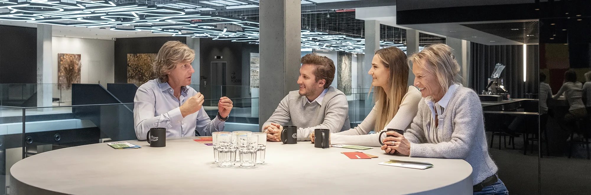 Jens Plath im Gespräch mit einem Team bestende auseinem jüngeren Mann und zwei unterschiedliche alten Frauen an einem Tisch