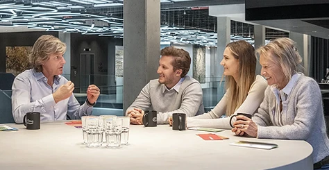 Jens Plath erklärt einem Team aus 3 Personen (ein Mann und zwei Frauen unterschiedlichen Alters) an einem Tisch